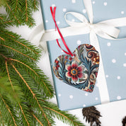 Heart-shaped Ukrainian style acrylic ornament with floral design on a polka dot gift box, surrounded by pine branches.