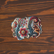 Scalloped Ukrainian style acrylic ornament with floral design on wood background