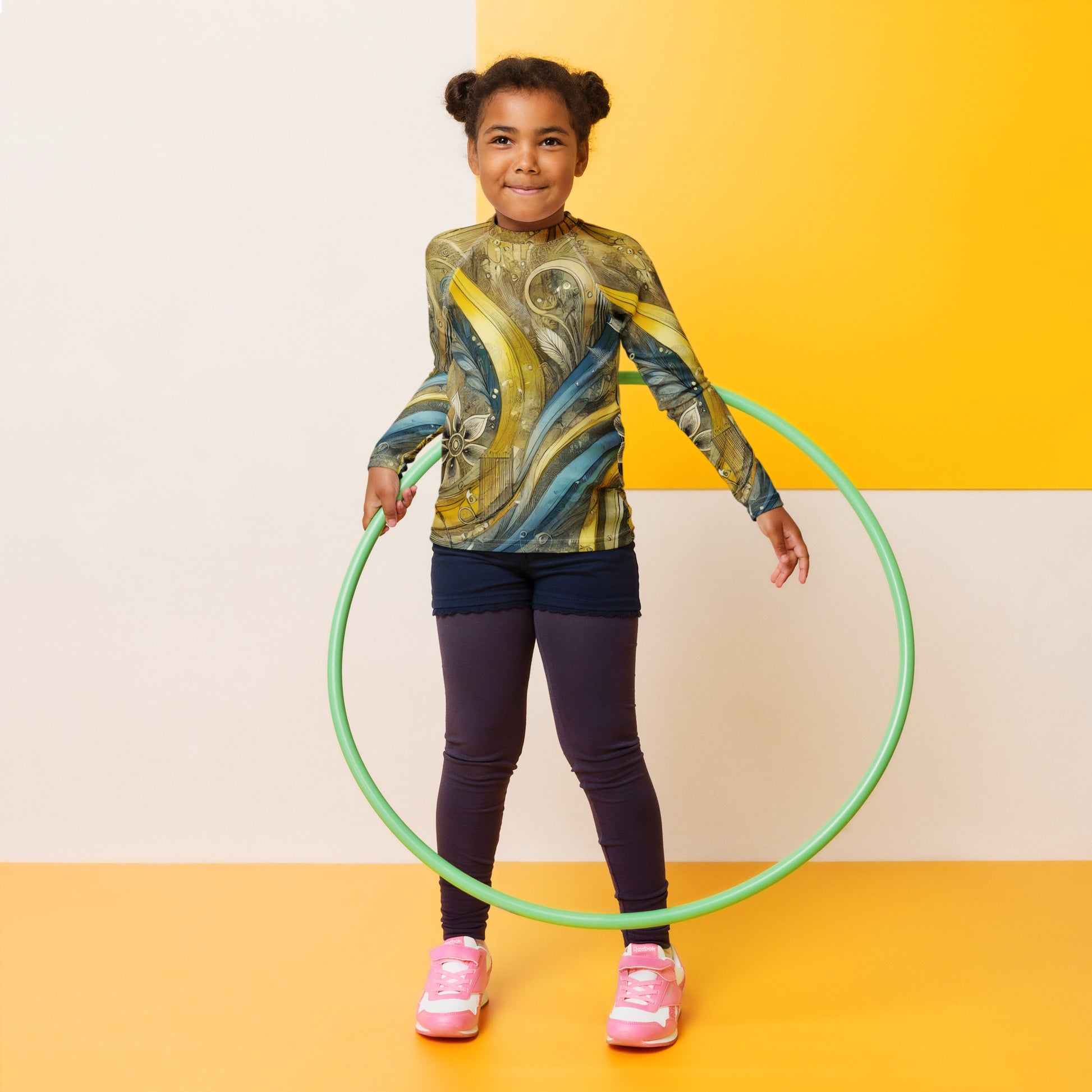 Child wearing a Ukrainian abstract design kids rash guard with UPF 50+, playing with a hula hoop indoors.