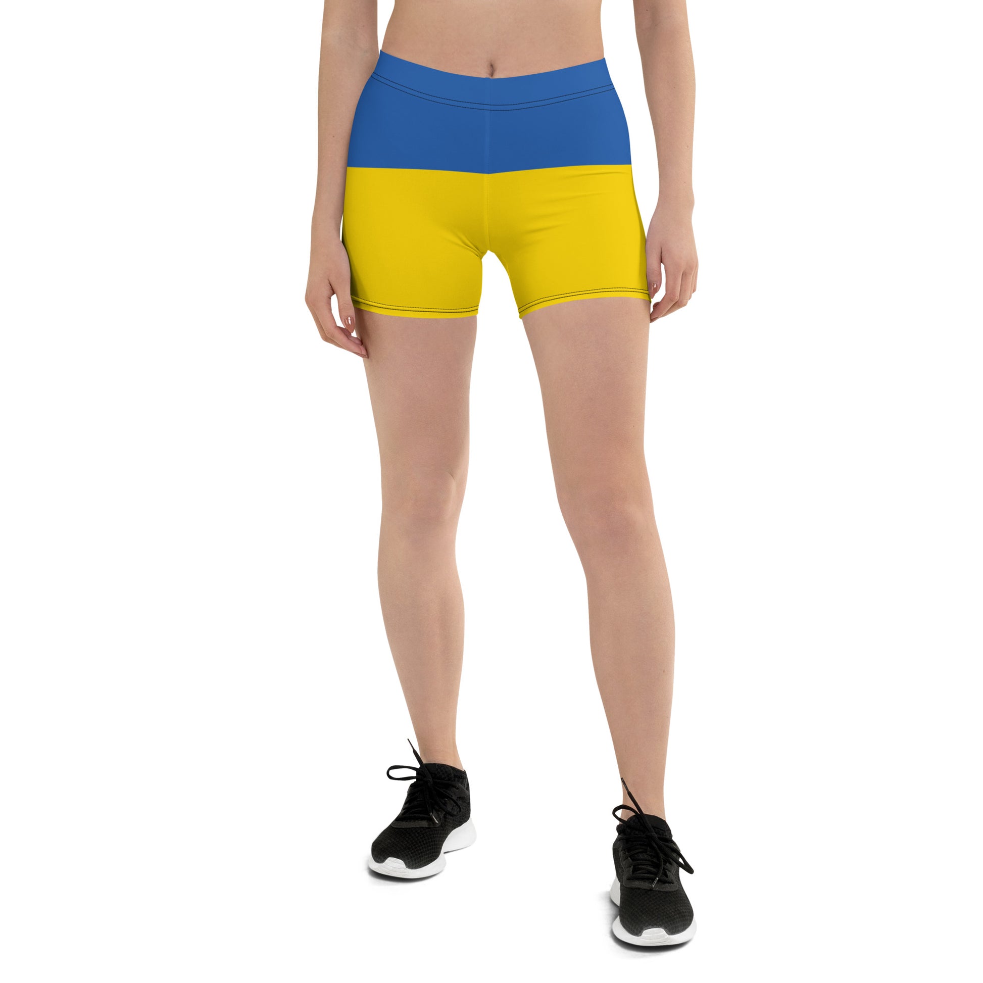 Woman wearing Ukrainian Flag shorts with blue and yellow design, part of the Ukrainian Vibe Trizub Collection, featuring four-way stretch fabric.