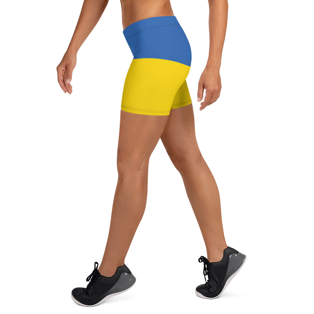 Woman wearing Ukrainian Flag shorts with blue and yellow design from Trizub Collection.