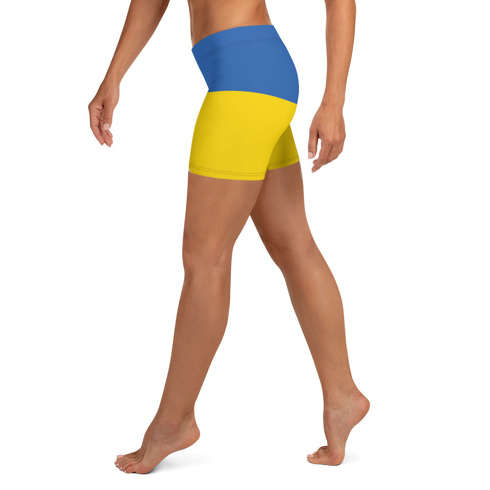 Woman wearing Ukrainian Flag shorts with blue and yellow design from the Ukrainian Vibe Trizub Collection, side view.