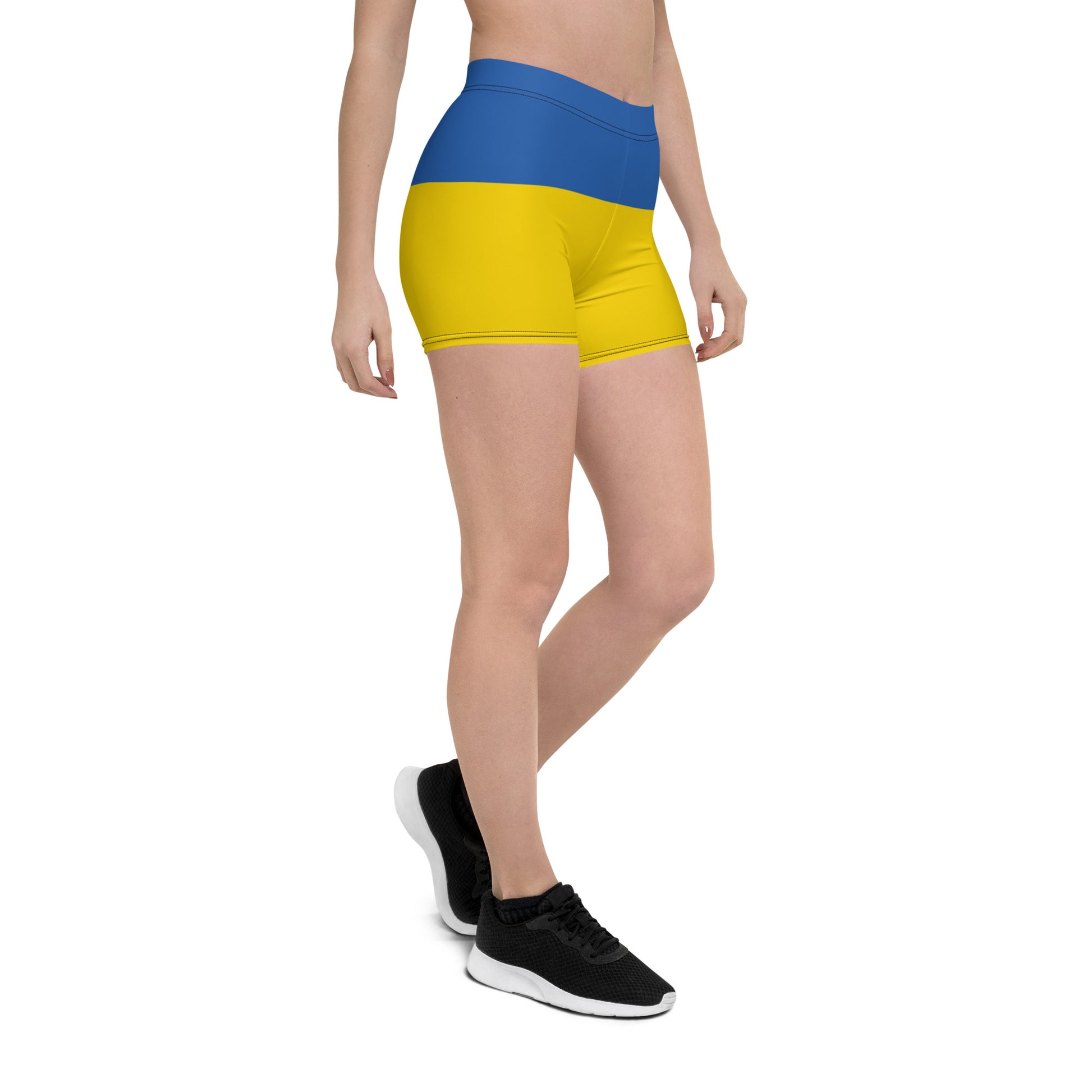 Woman wearing Ukrainian Flag shorts with blue and yellow design, part of the Ukrainian Vibe Trizub Collection, side view.