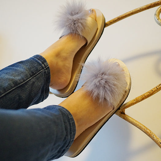 Person wearing Anelie mink fur slides with recycled fur, paired with jeans, showcasing the chic and sophisticated footwear design.