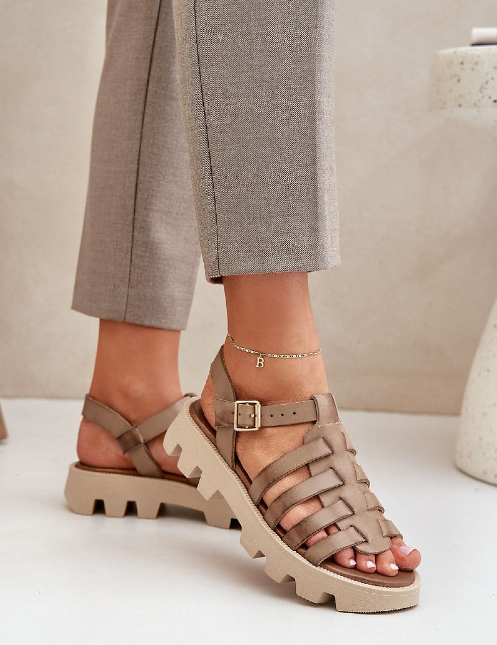 Woman wearing Antonia Stud Platform Sandals in natural leather with buckle strap, showcasing chic and edgy style against a neutral background.
