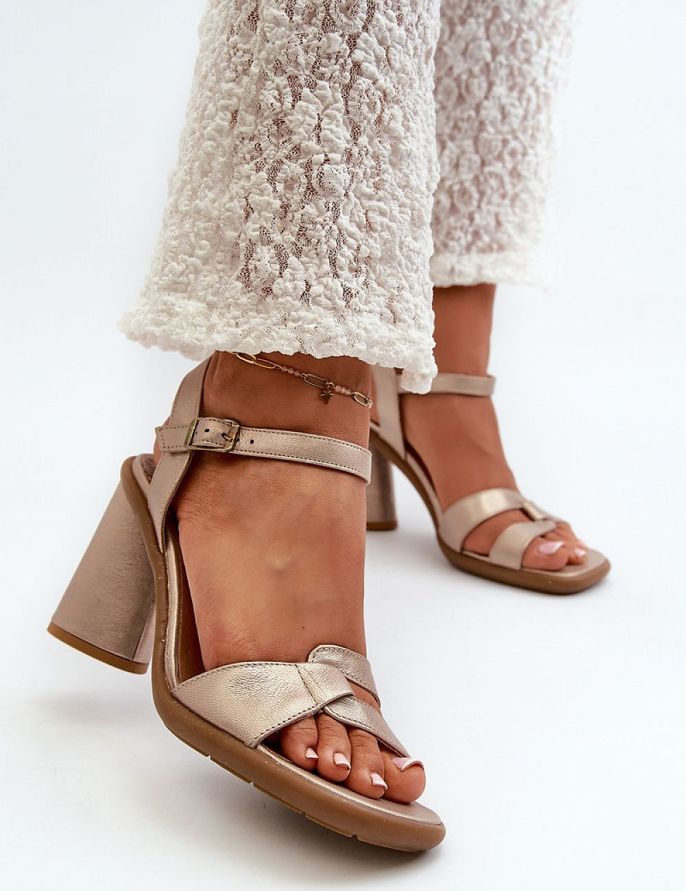 Woman wearing Ardella Tri-Heel Leather Sandals with triangular heel, adjustable buckle strap, and smooth leather finish.