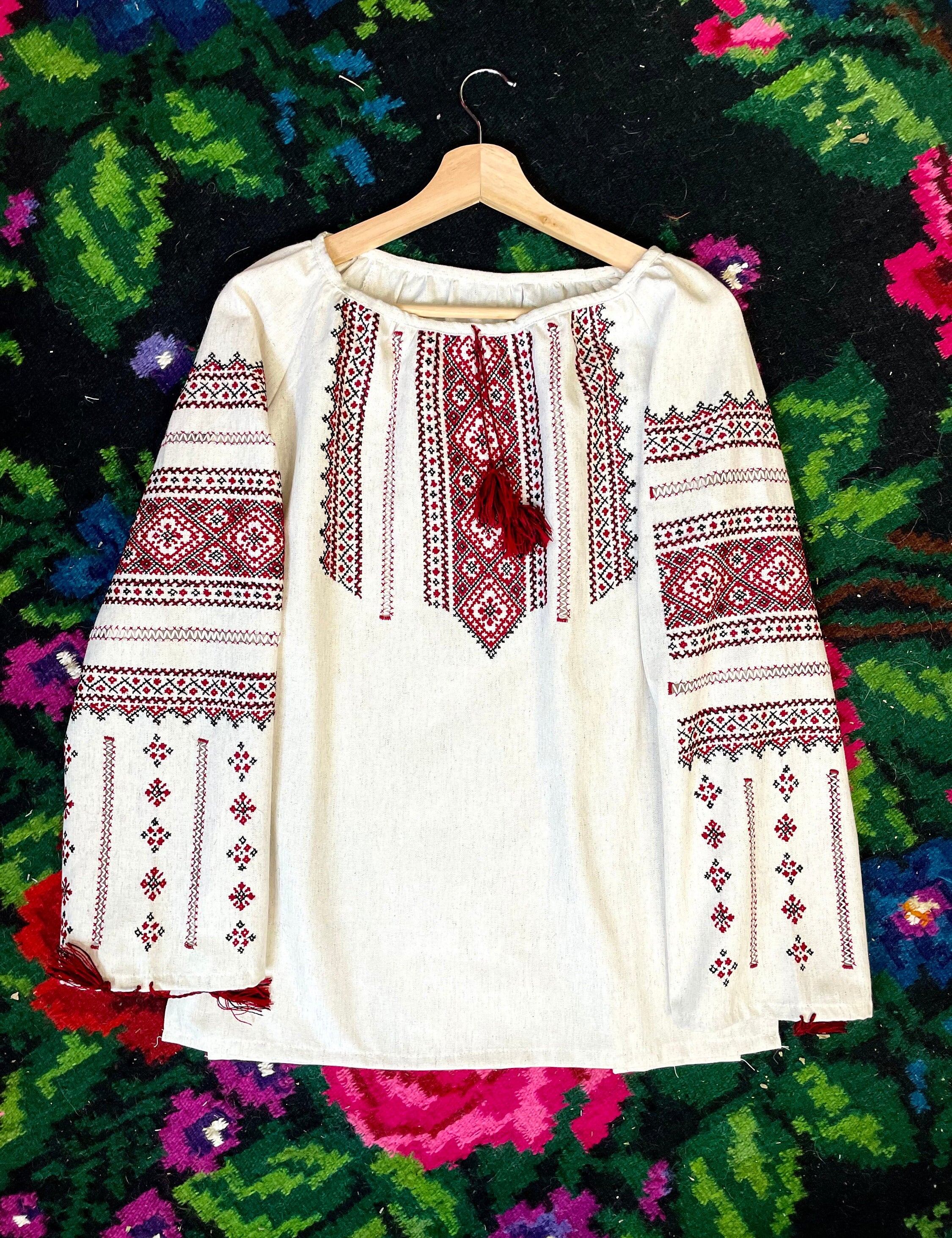 Authentic Ukrainian embroidered Vyshyvanka blouse with red cross-stitch on white fabric, showcasing folklore Bohemian style.