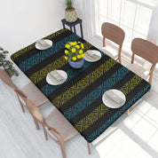 Ukrainian embroidery table cover on dining table with vibrant blue and yellow patterns, set with plates and yellow flowers.