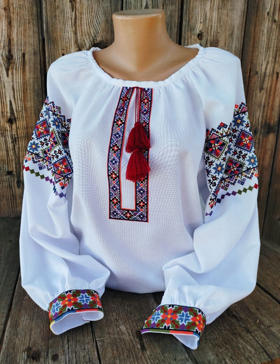 Authentic Ukrainian women's vyshyvanka, white with vibrant folk embroidery, symbolizing heritage and elegance. Tailored and handmade.
