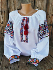 Authentic Ukrainian women's vyshyvanka, white with vibrant folk embroidery, symbolizing heritage and elegance. Tailored and handmade.