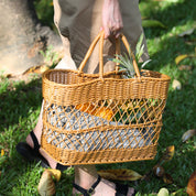 Handmade rattan-like picnic basket held outdoors, showcasing woven design perfect for picnics, shopping, or decor.