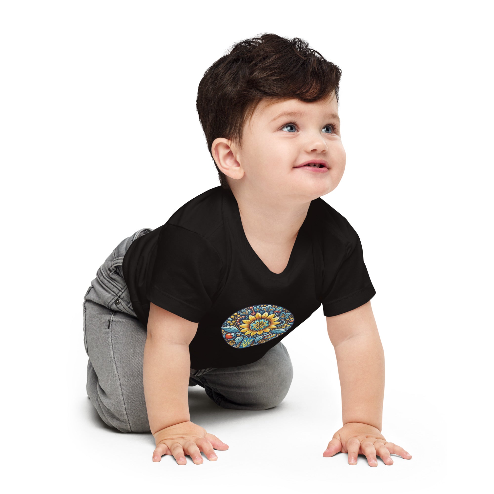 Baby wearing a black jersey tee with Ukrainian symbol design, crawling on the floor, showcasing soft and comfortable cotton fabric.