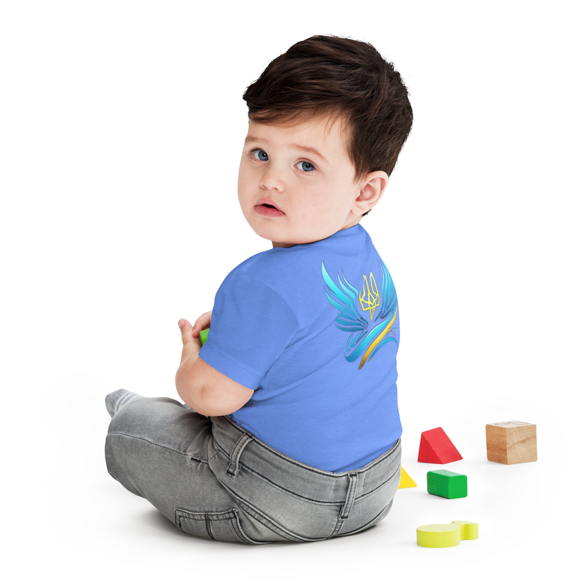 Baby wearing a blue jersey short sleeve tee with Ukrainian symbol, sitting with colorful blocks.