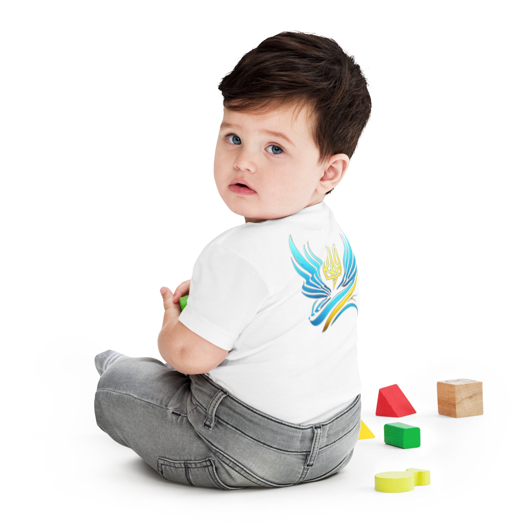 Baby wearing a jersey short sleeve tee with Ukrainian symbol design, sitting with colorful blocks.