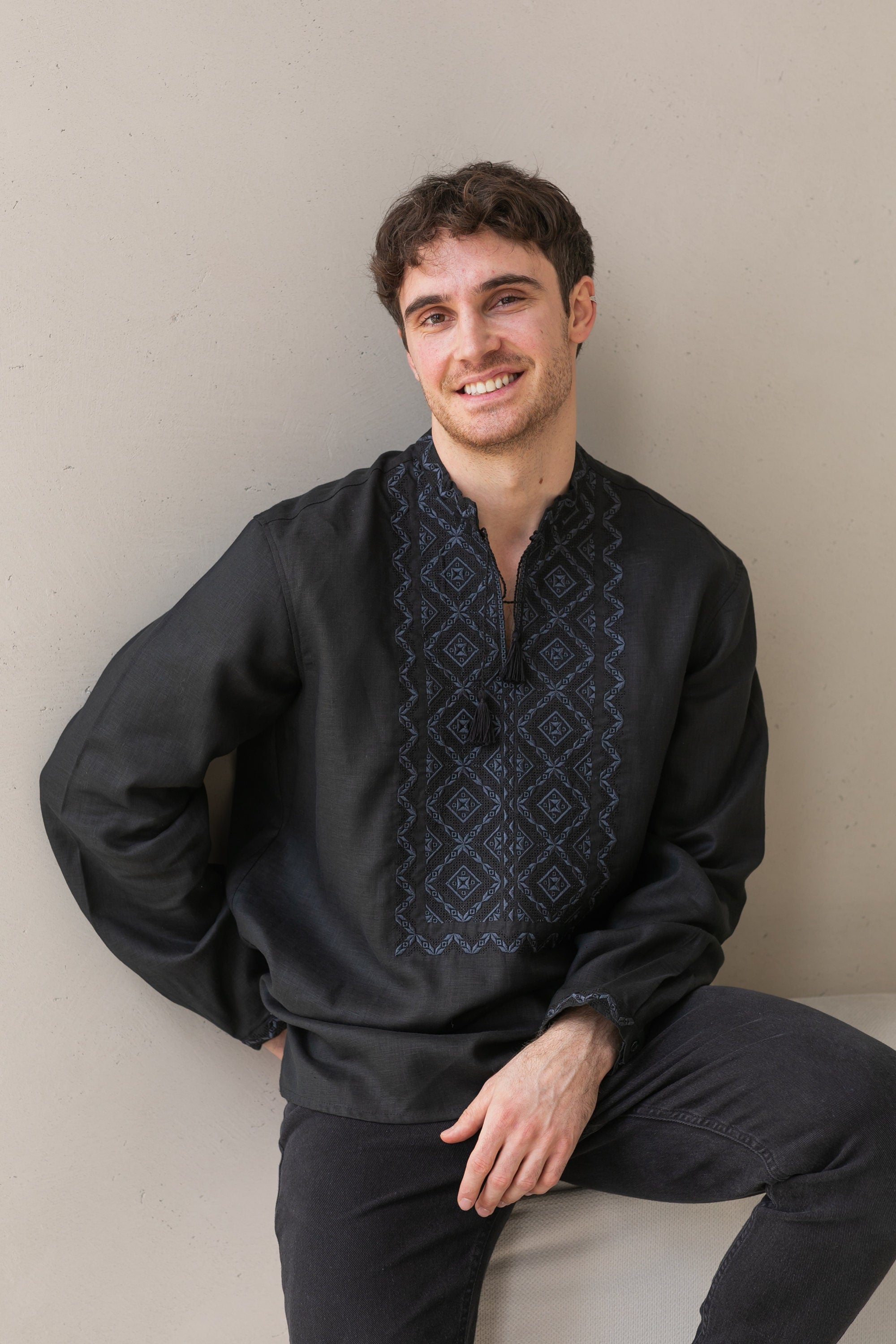 Young man wearing a black linen embroidered shirt with traditional Ukrainian Poltava motifs, showcasing classic elegance and craftsmanship.