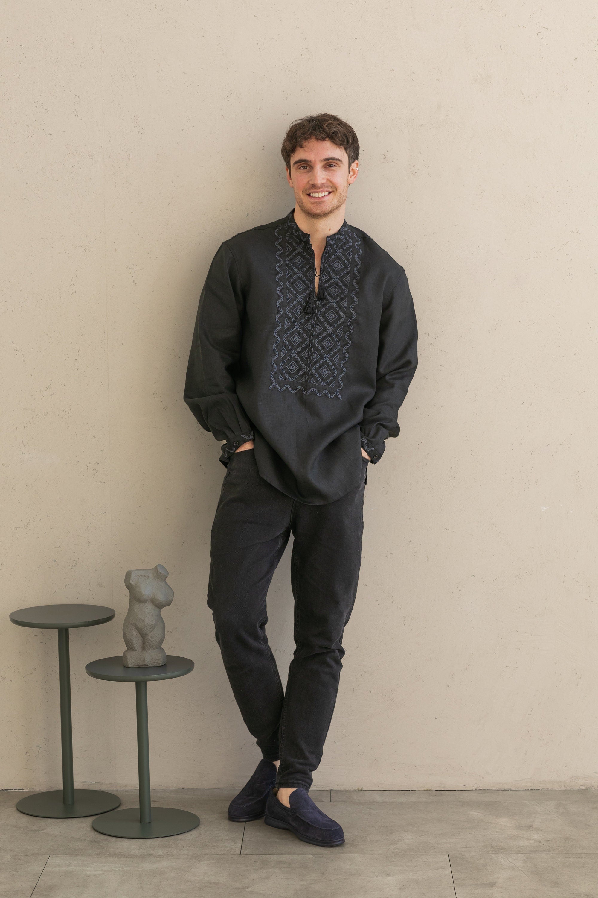 Black linen men's shirt with traditional Poltava embroidery, featuring elegant black-on-black cross-stitch design, worn by a model.