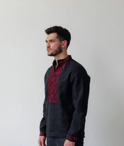 Black linen men's shirt with red geometric Ukrainian embroidery, vyshyvanka style, featuring stand-up collar and long sleeves.