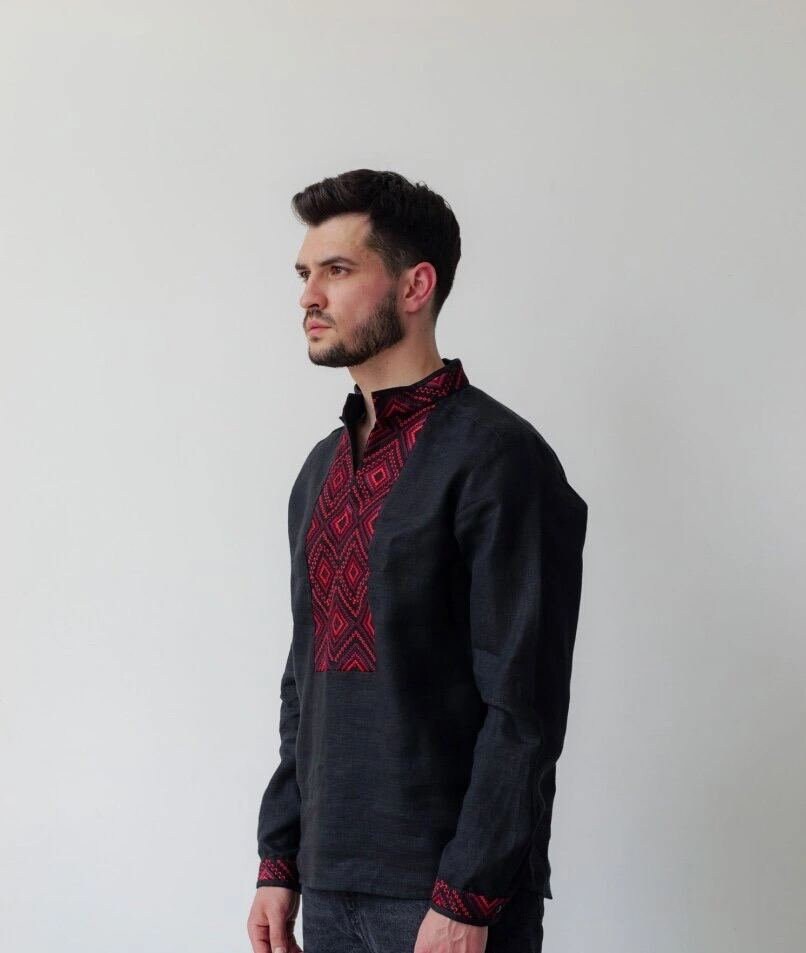 Black linen men's shirt with red geometric Ukrainian embroidery, vyshyvanka style, featuring stand-up collar and long sleeves.