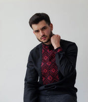 Man wearing black linen Ukrainian Vyshyvanka shirt with red geometric embroidery, showcasing traditional Slavic folk motifs.