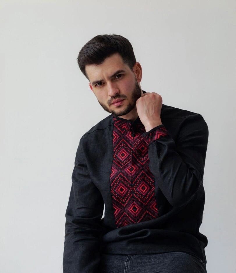 Man wearing black linen men's shirt with red geometric embroidery, Ukrainian Vyshyvanka style, Symbolizes strength and well-being