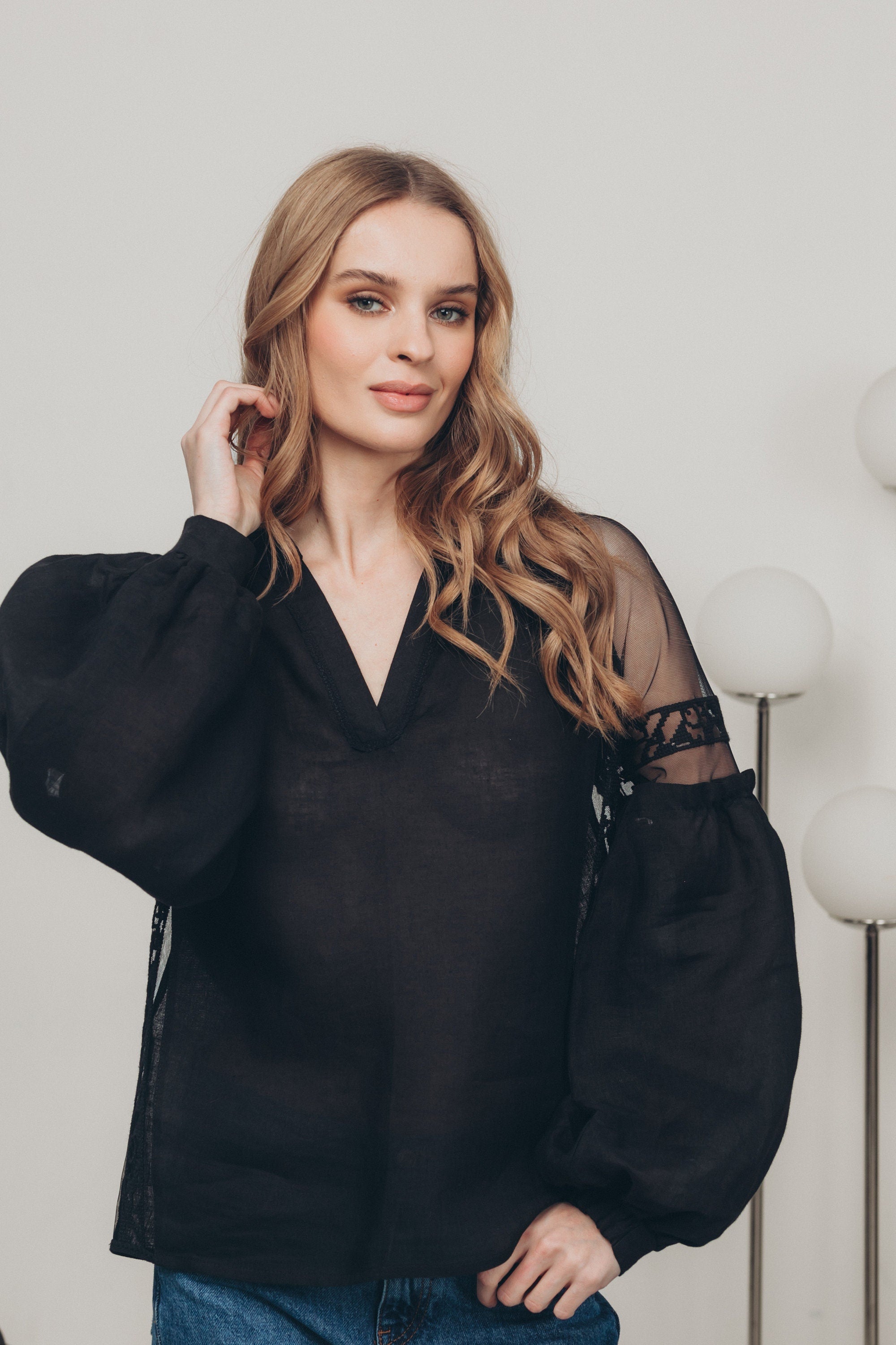 Woman wearing black-on-black embroidered blouse with tulle shoulders, styled in boho ethnic fashion.