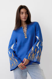Blue linen embroidered blouse, Ukrainian vyshyvanka shirt for women, featuring satin stitch ornament and loose-fit design.