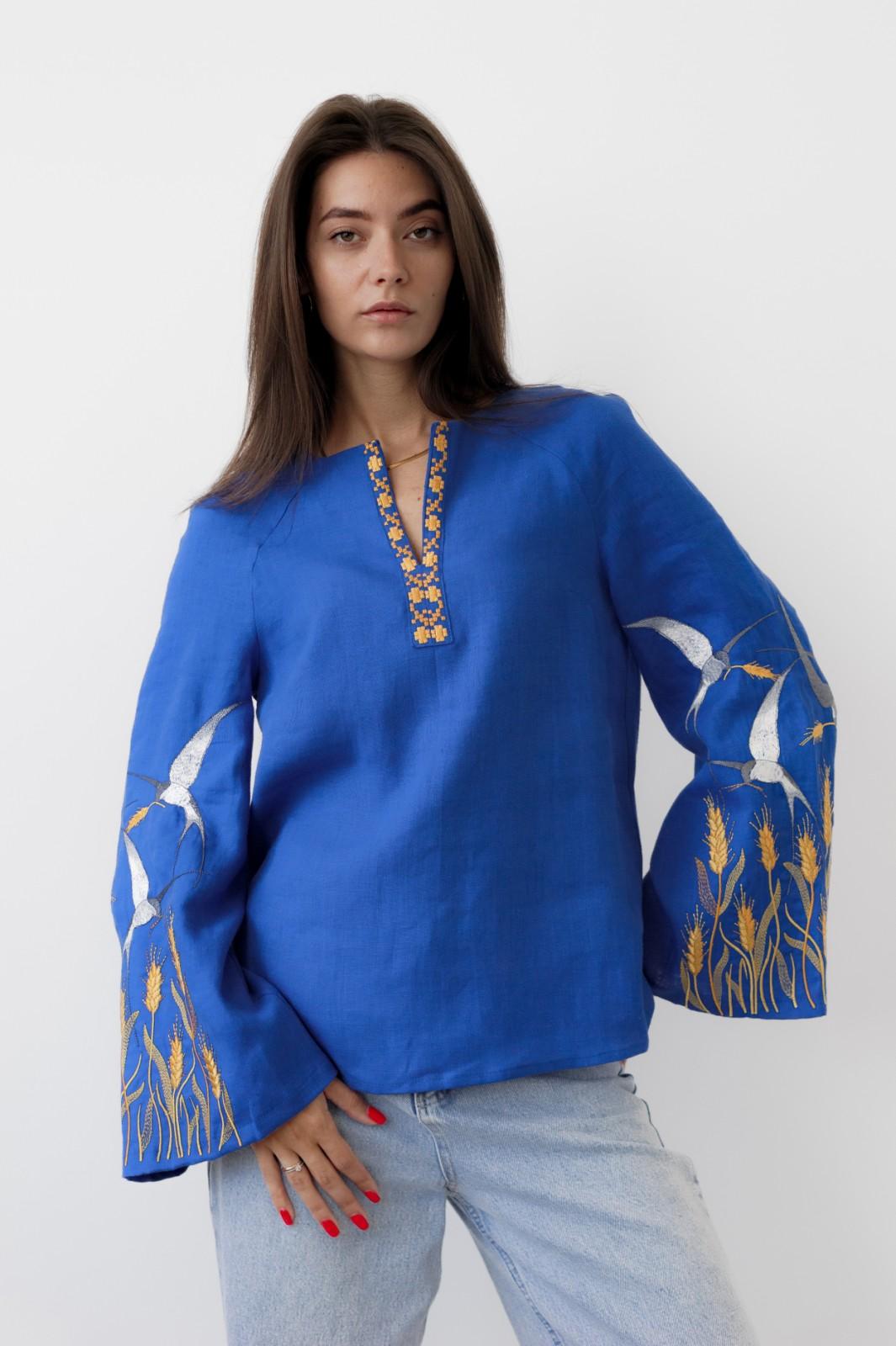 Blue linen Ukrainian Vyshyvanka blouse with satin stitch embroidery, model wearing traditional embroidered shirt, casual fit.