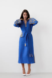 Woman wearing blue linen embroidered Vyshyvanka dress with boho style.