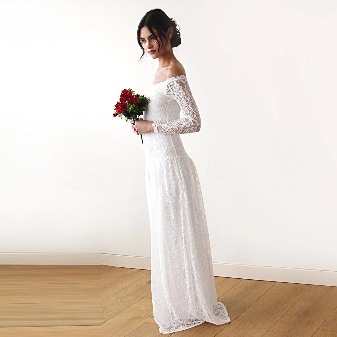 Elverin Medieval Lace Wedding Dress with off-shoulder neckline and lace sleeves, captured alongside a floral bouquet, bridal elegance.