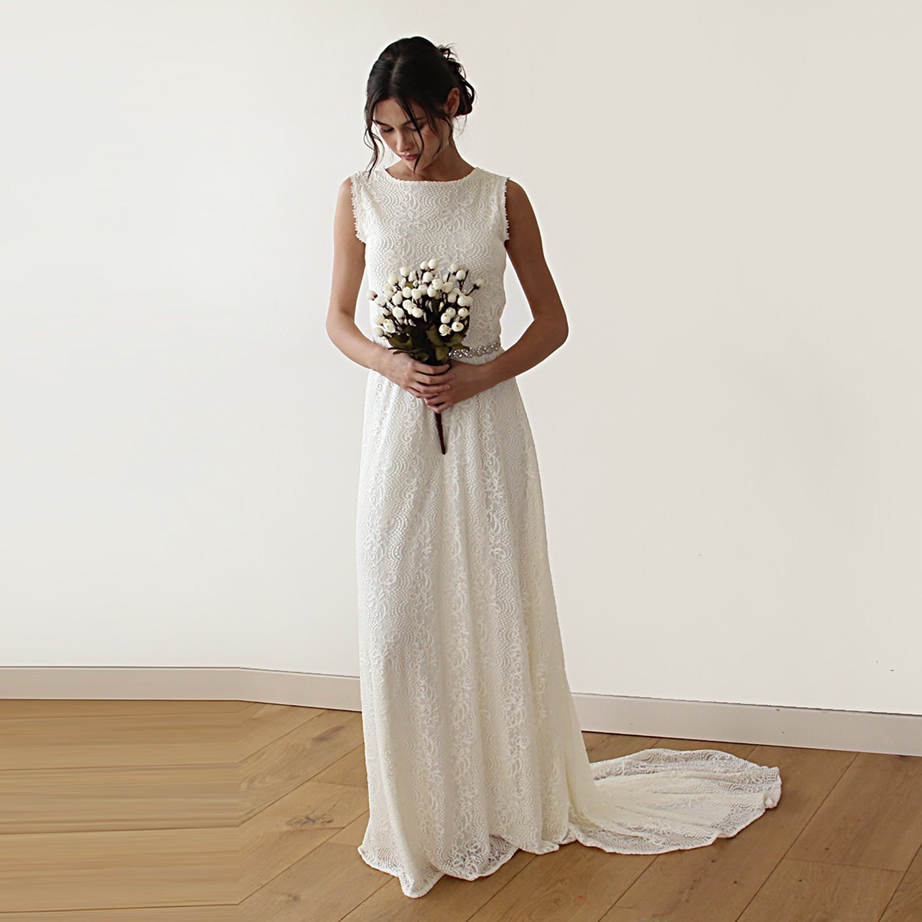 Bride wearing Solenne Sleeveless Lace Wedding Dress with Train, featuring a high boat neckline and ivory lace fabric.