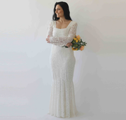Woman wearing Elirelle Ivory Lace Wedding Dress with Sleeves, featuring a square neckline and mermaid silhouette, holding a bouquet.