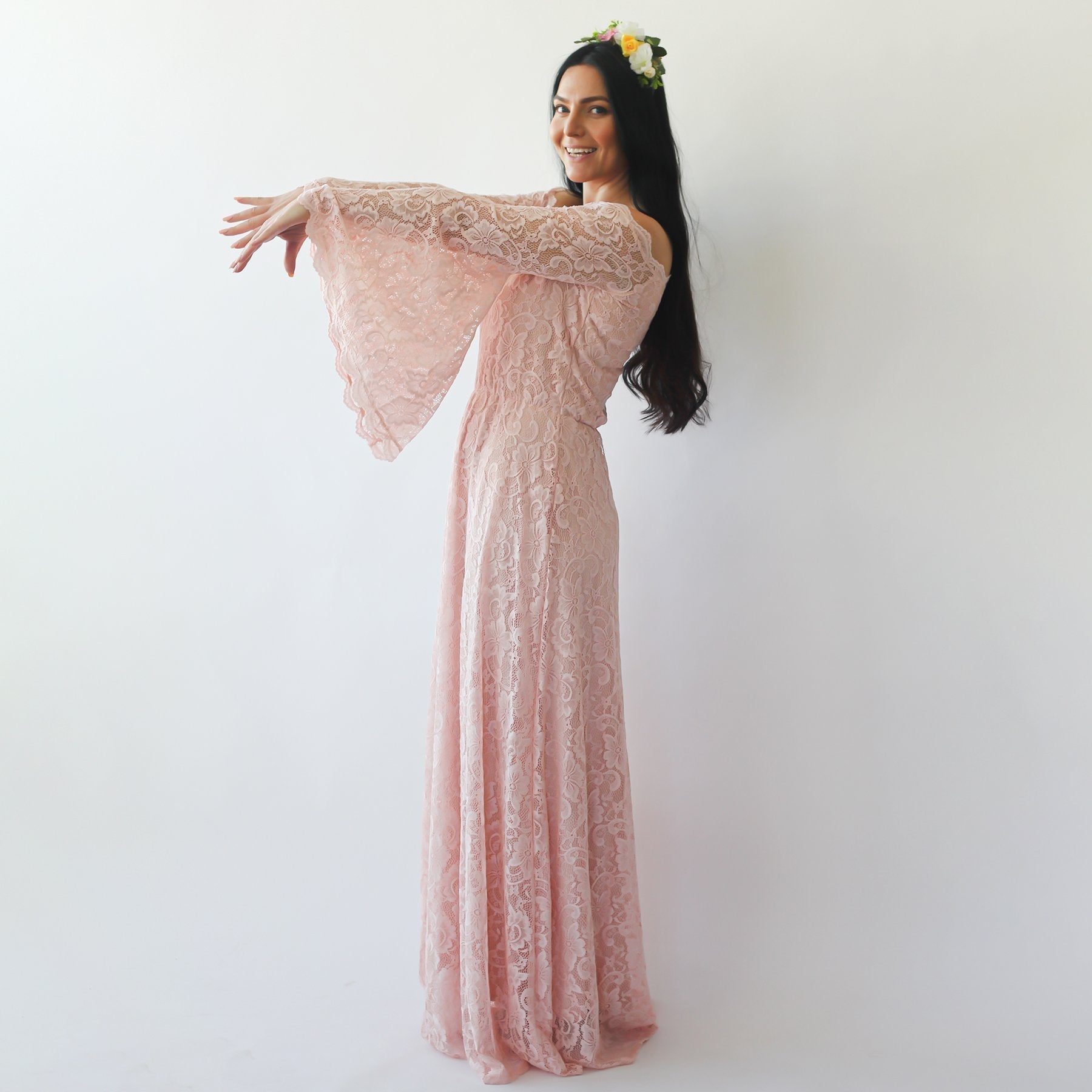 Bride wearing Elidoria off-shoulder wedding dress in blush lace with bell sleeves, showcasing bohemian elegance and modern charm.