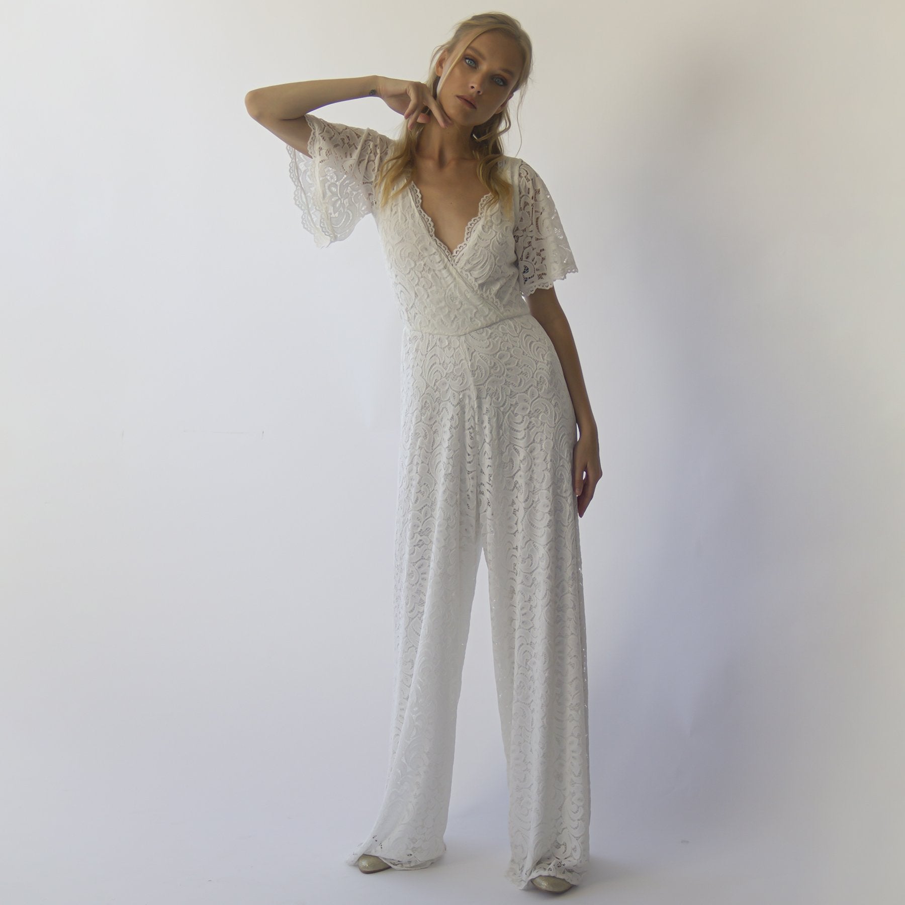 Ivory lace bridal jumpsuit with wrap-effect bodice and short sleeves, perfect for modern brides seeking elegance and comfort.