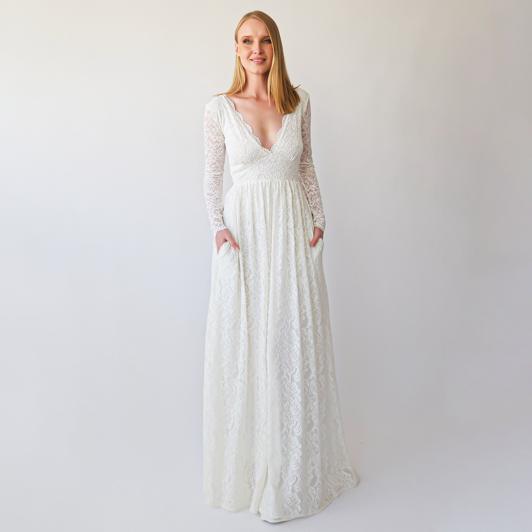 Thaleira Empire Waist Wedding Dress with lace, V-neckline, long sleeves, and flowing silhouette for boho garden weddings.