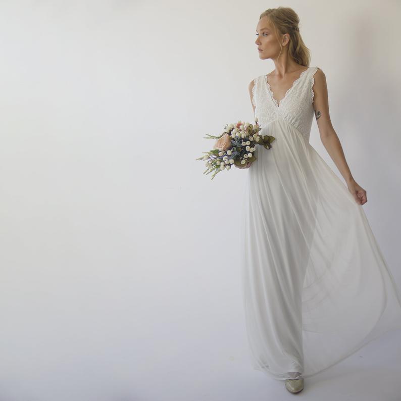 Ivorelle Open-Back Wedding Gown with lace bodice, chiffon skirt, and V-neckline, ideal for garden ceremonies, woman holding bouquet.