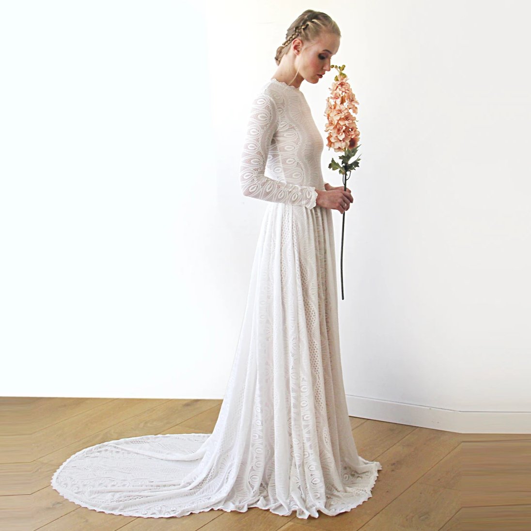 Model wearing Elenthera modest train wedding gown with geometric lace, jewel neckline, long sleeves, and sweeping train.