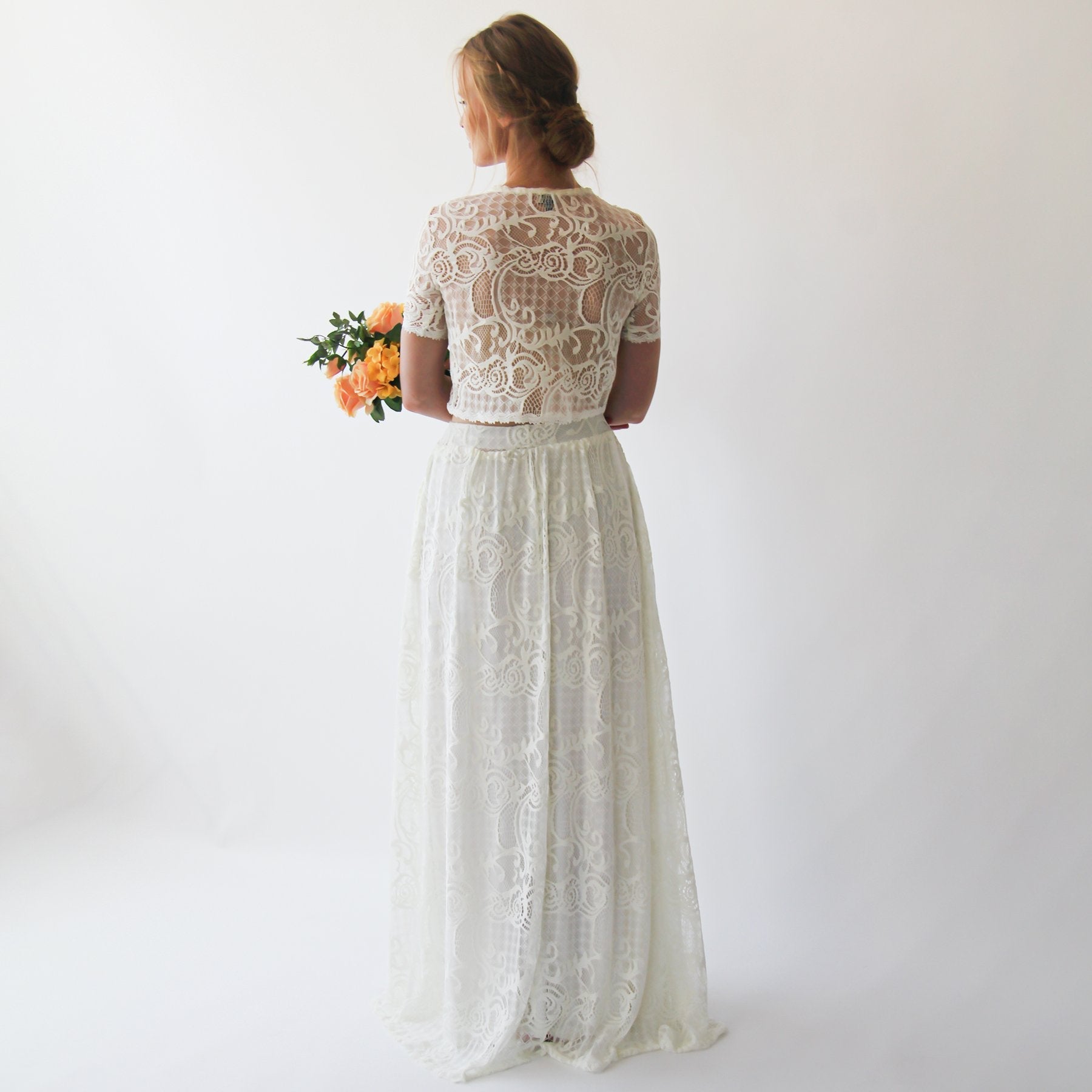 Rear view of Lyssara two-piece wedding dress with lace skirt, showing lace crop top and flowing full-length skirt.