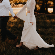 Ivory lace two-piece wedding ensemble with bell sleeves, perfect for a romantic, bohemian bridal look.