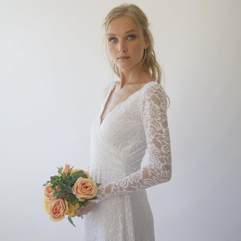 Bohemian bridal in Aurelene Long Sleeve Wrap Gown with lace sleeves and bouquet, showcasing timeless elegance for wedding day.