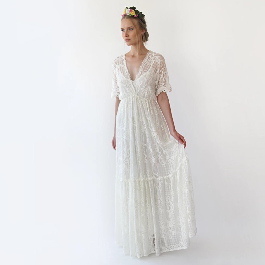 Ivairin lace wedding gown with bat sleeves and deep V-neck, ideal for modern boho brides. Features floral lace and flowing silhouette.