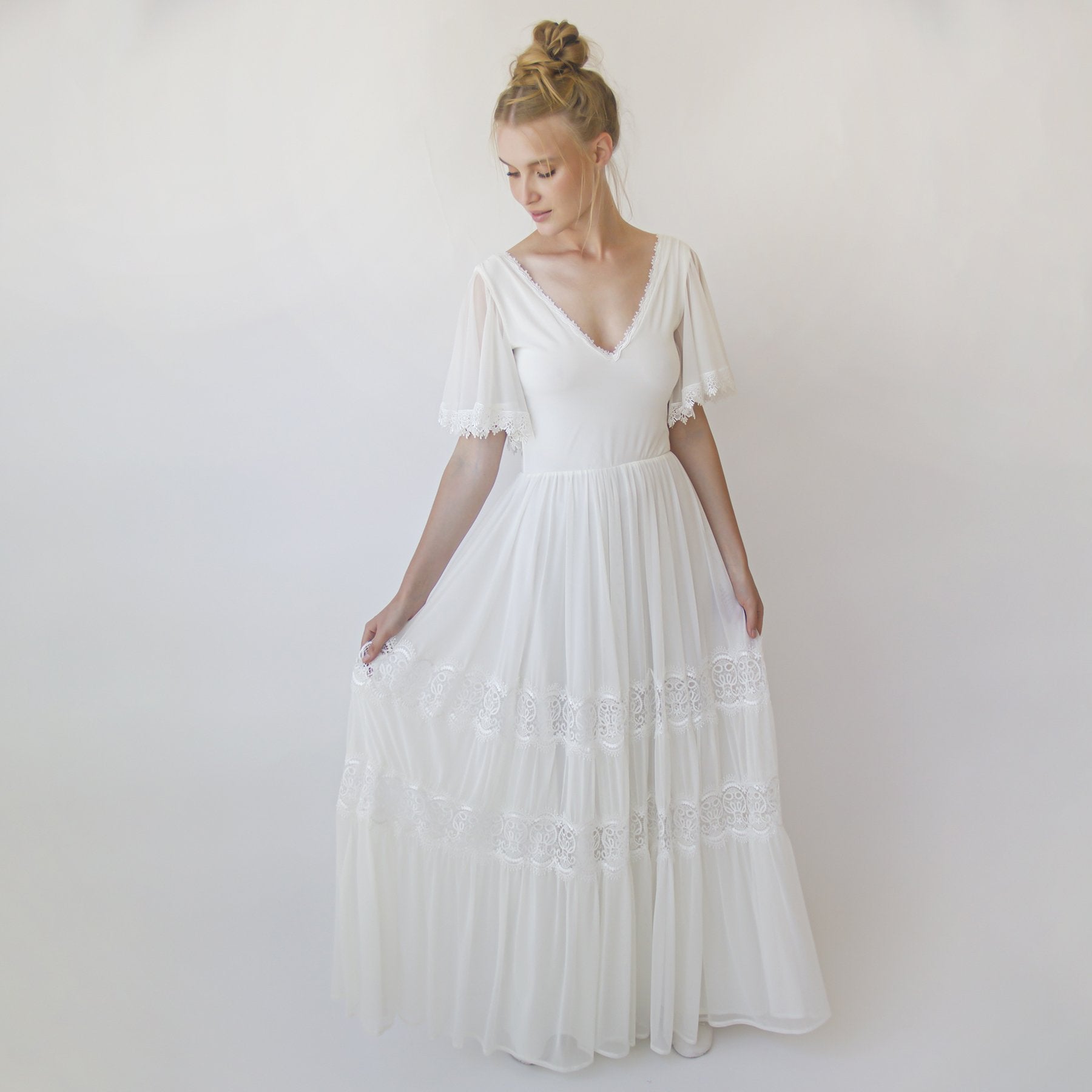Bride wearing Myrielle Chiffon Butterfly Wedding Dress with floral appliqué, butterfly sleeves, and plunging V-neckline.