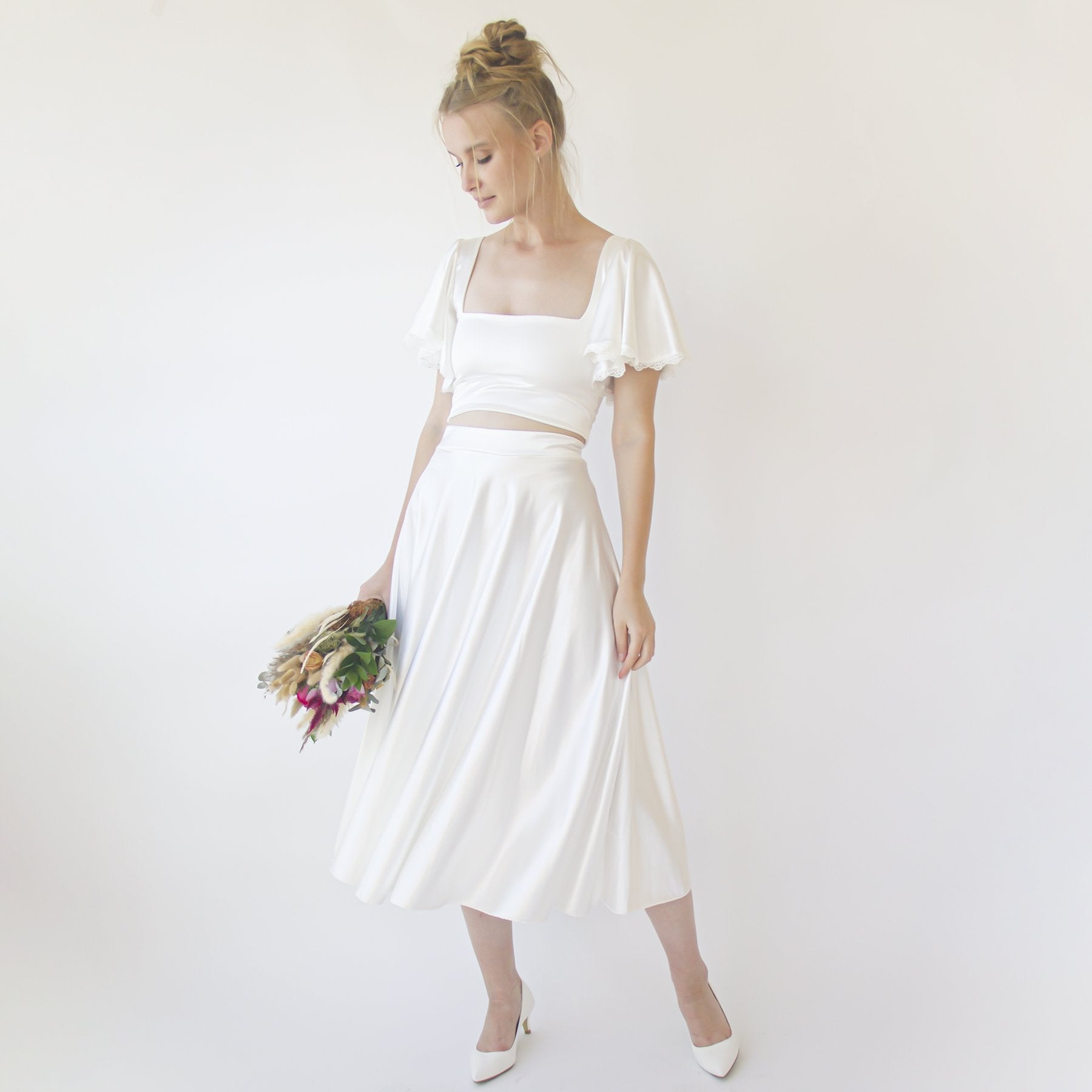 Elegant woman wearing Loraine Ivory Satin Midi Wedding Skirt, showcasing elegance and grace for modern brides.