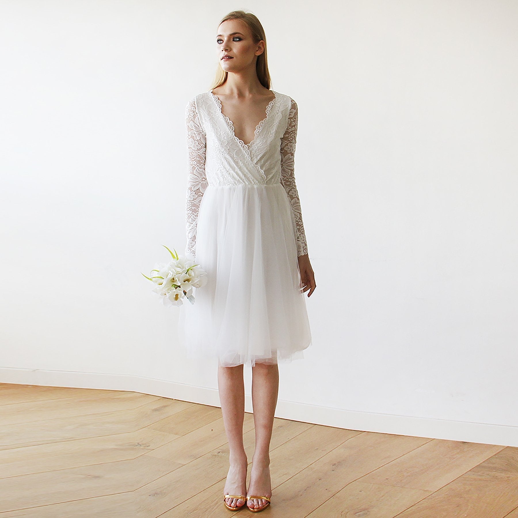 Ivory Ivarelle midi tulle wedding dress with V-neckline and lace sleeves, perfect for spring weddings, shown holding bouquet.