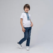 Boy wearing short sleeve blue embroidered Ukrainian vyshyvanka shirt with jeans, showcasing traditional and modern style.