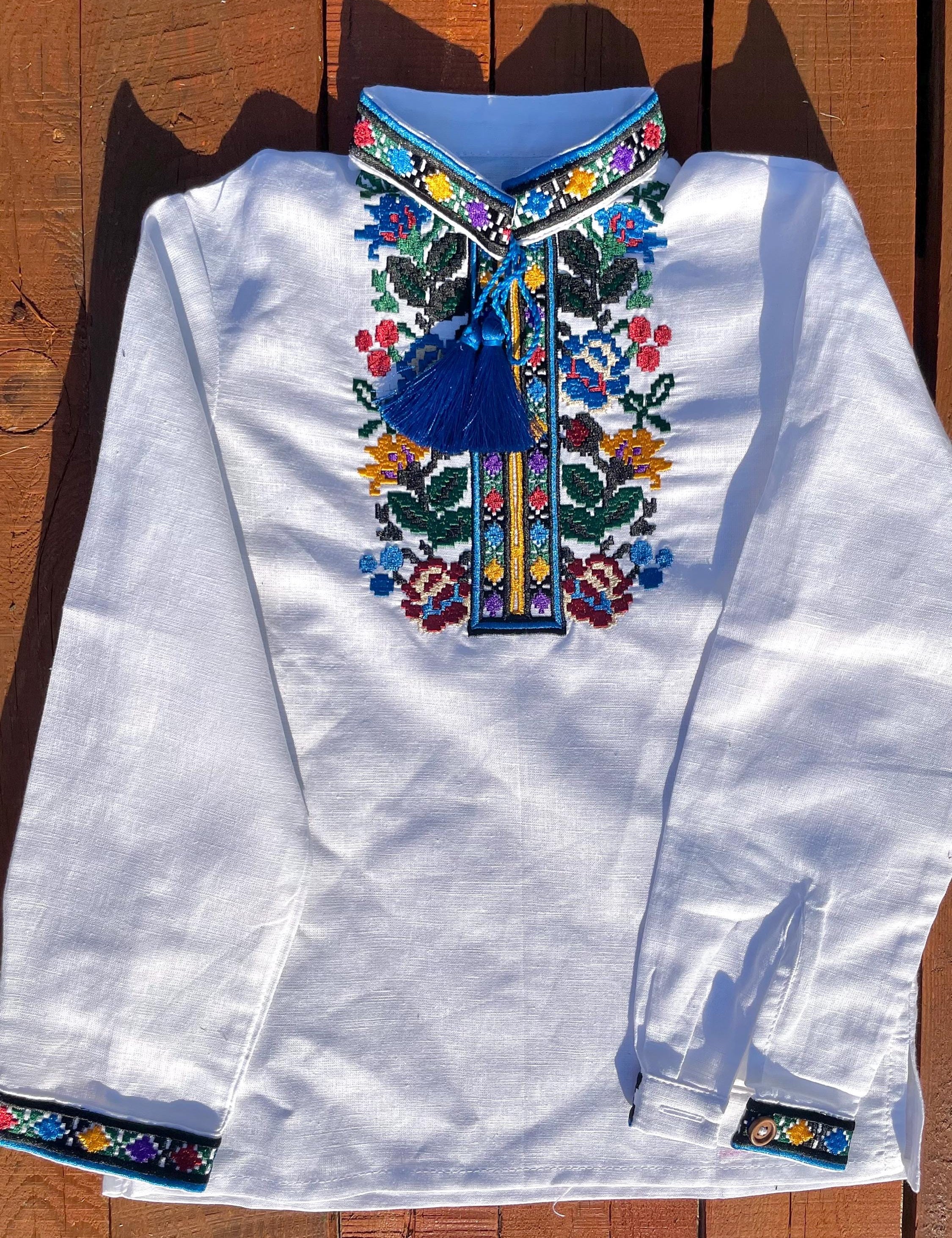 Boys' embroidered linen shirt with traditional Ukrainian vyshyvanka floral patterns, multicolor embroidery on chest, cultural attire.