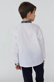 Boy wearing a white linen shirt with traditional Ukrainian embroidery on collar, showcasing back view. Ideal for cultural events.