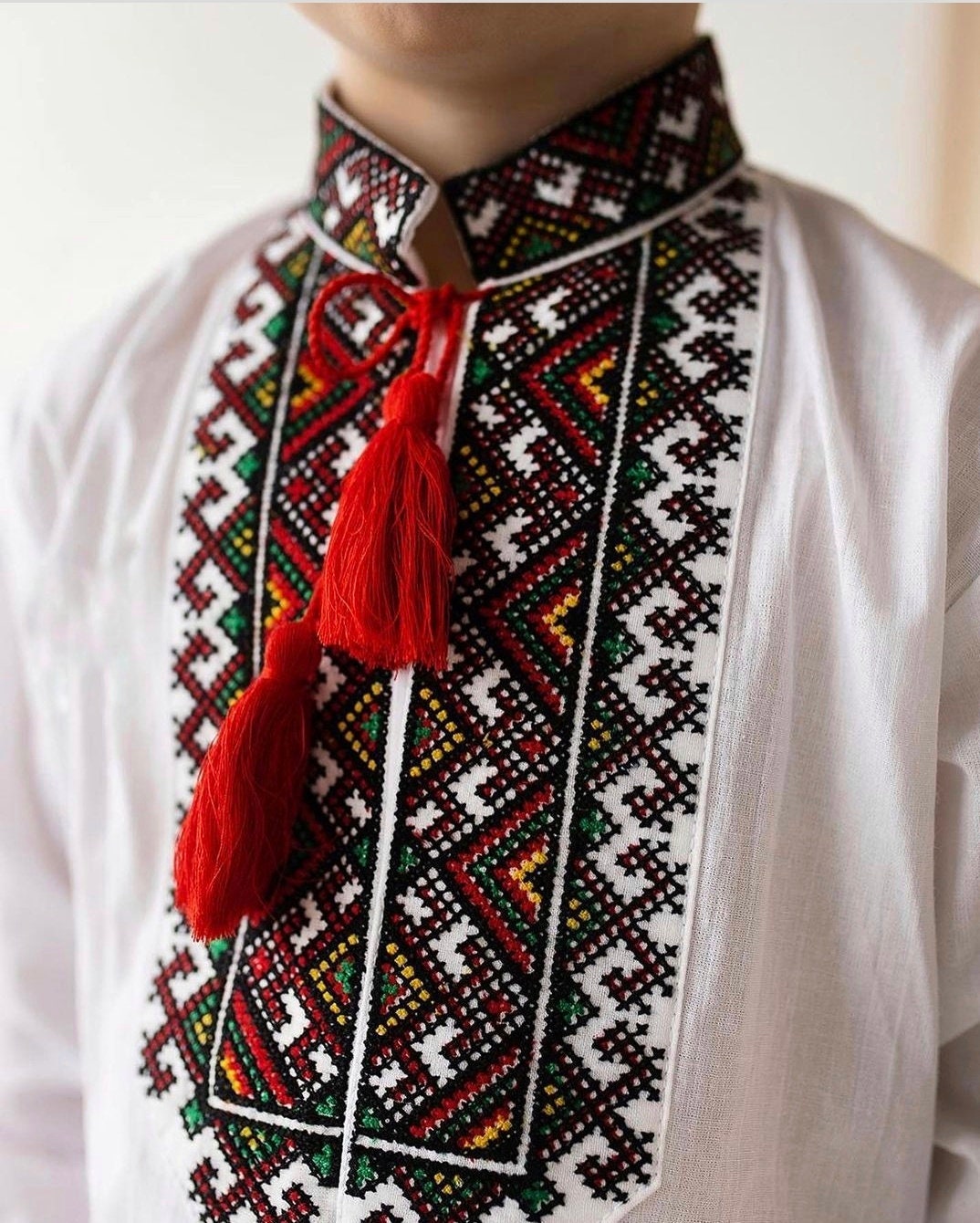 Boys embroidered Vyshyvanka shirt with traditional Ukrainian design and red tassels
