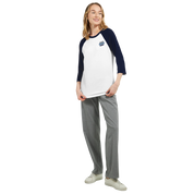 Woman wearing Mervelle Raglan Sleeve Tee in white with contrasting navy sleeves and gray pants for casual style.