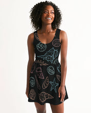 Woman wearing Shelllight Skater Dress with seashell design, featuring a scoop neckline and shirred skirt, perfect for breezy summer days.