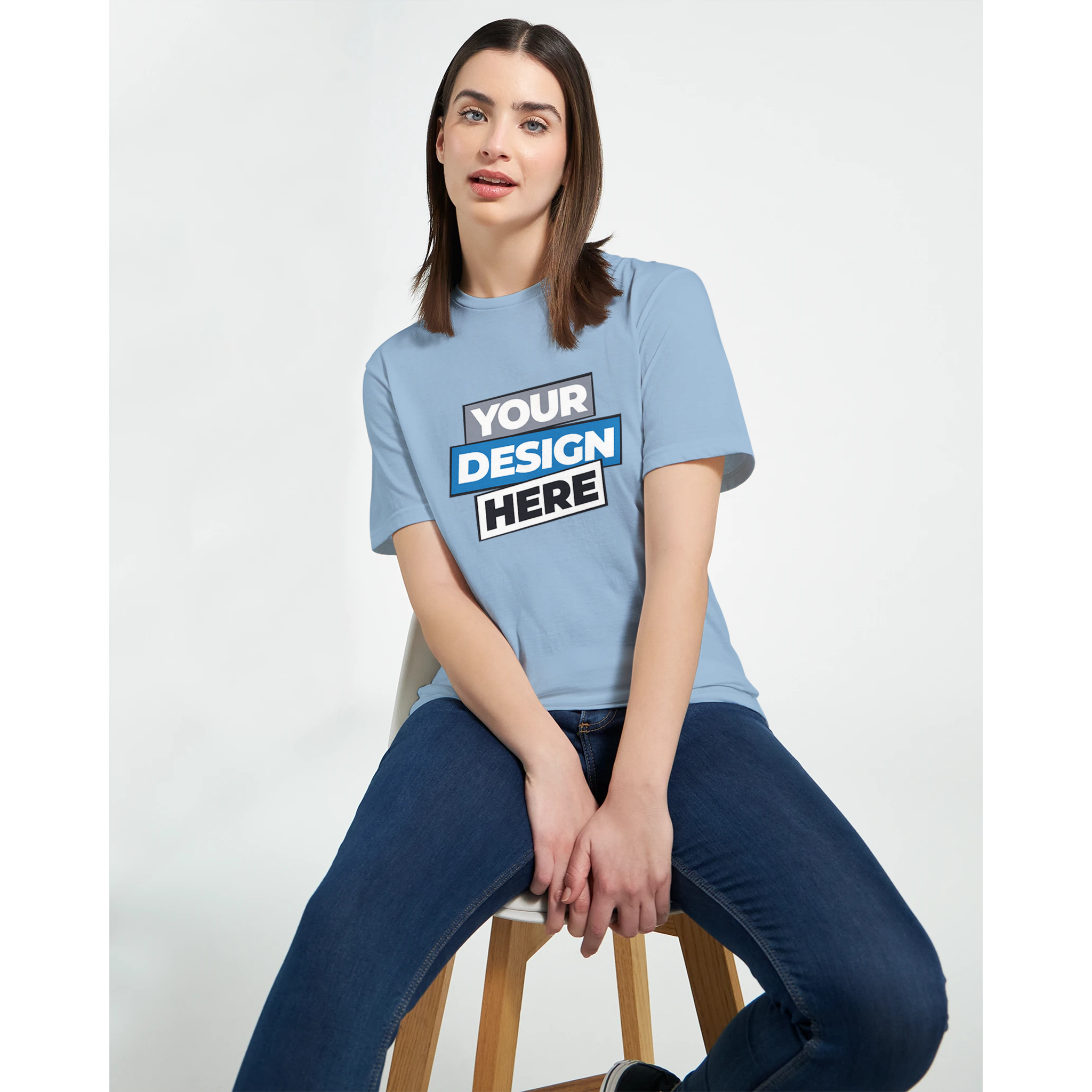 Woman wearing a customizable Zalmera cotton t-shirt with a design template, sitting on a stool, showcasing style and comfort.